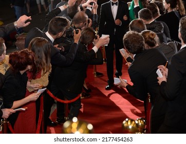 celebrity on the red carpet. man and woman in evening dresses among photographers and fans on the red carpet - Shutterstock ID 2177454263