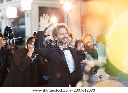 Celebrity waving for paparazzi at event
