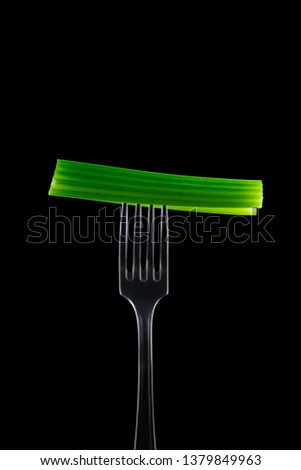 Celery on Fork with black background. Celery isolayed.