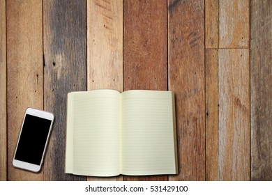 Cell Phone And Book On Wood