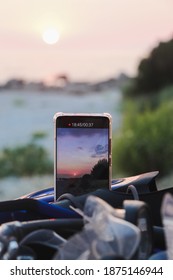 Cell phone capturing the time lapse of sunset, filming with cell phone from the beach. Background is out of focus.