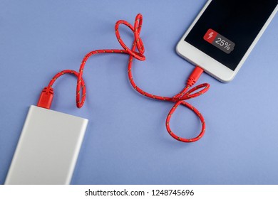 Cell Phone Charging Via External Battery Through Red USB Cable. Keep Your Gadgets Alive All Day.