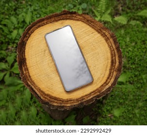 cell phone lies on the old a tree stump the summer in a garden. Mobile phone against brown dry new stump, Mobilephone. black empty screen. mock up. - Powered by Shutterstock