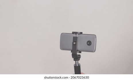 Cell Phone Mounted On A Cell Phone Tripod, On White Background.