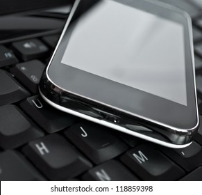 Cell Phone On Laptop Keyboard - Business Concept