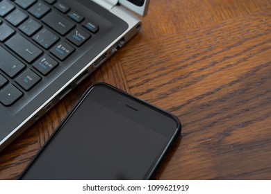 Cell phone sharing data next to laptop - Internet security and protect against spy ware
