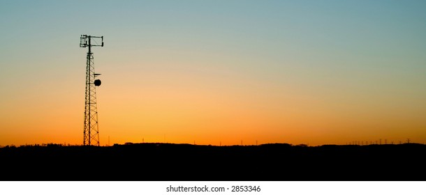 A Cell Phone Tower Silhouette In The Sunset