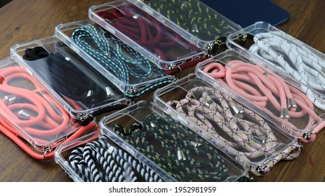 Cell Phone Transparent Case And Colorful Ropes On A Wooden Table