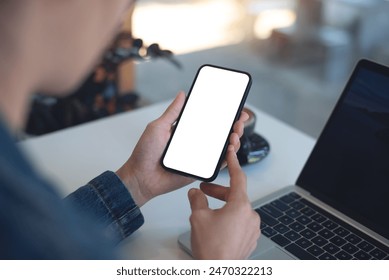 Cell phone white screen mockup, Woman hand holding mobile phone with blank screen while working at coffee shop. Business woman using smartphone, mockup for social media marketing - Powered by Shutterstock