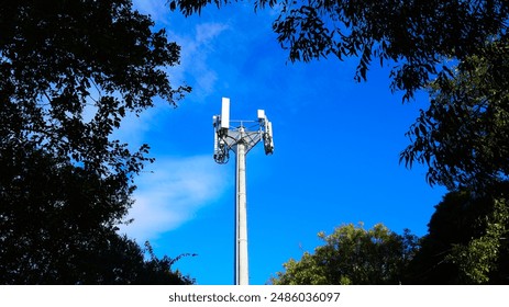 Cell tower with 5G antennas at blue sky - Powered by Shutterstock