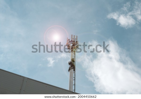 Cell tower. Tower of the fifth generation\
network. Sun at noon on a clear\
sky