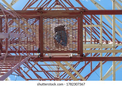 Cell Tower Service Engineer Is Climbing Up On Stairs Of Cell Tower.