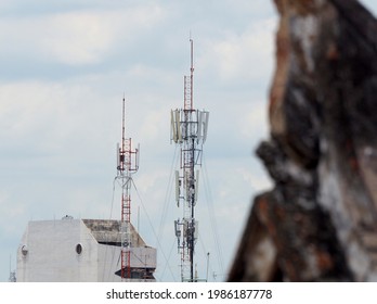 Cell Tower With Sky And Building Background And Blur Tree Front Ground