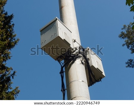 Cell tower with two instrument boxes on blue sky