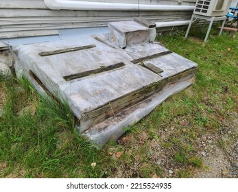 A Cellar Door That Has Plastic Placed Over It And Has Pieces Of Wood Nailed To It To Hold The Plastic In Place. There Is No Access To The Cellar.