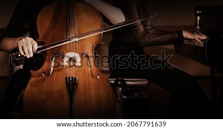 Cello and piano players. Duet of cellist and pianist playing ensemble. Classical music instruments close up.