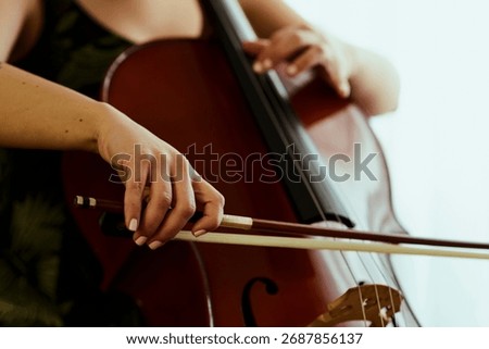 Cello player bow on strings close up
