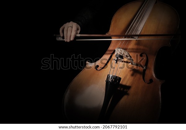 Cello player. Cellist\
hands playing cello with bow strings musical instrument closeup.\
Violoncello