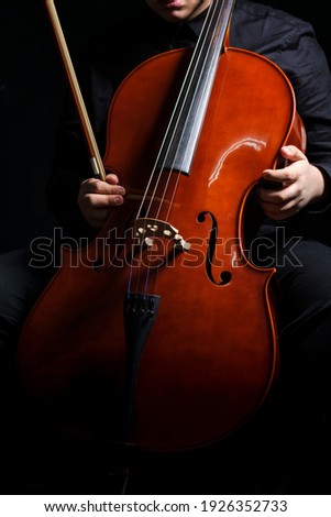 Cello player or cellist performing
