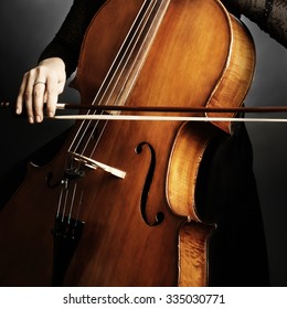 Cello player cellist playing music instrument hands closeup. Orchestra instruments