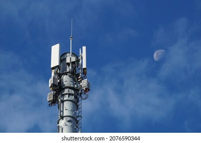 Cellular 5G network technology mobile telecommunications tower with antennas, cables, electronic radio modules providing wideband low latency high-speed connection for customers with newest 5G phones