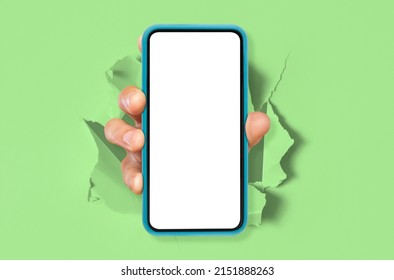 Cellular App. Male hand holding smartphone with white empty screen showing device close up to camera breaking through torn green paper sheet. Gadget display with free copy space, mock up. Great Offer - Powered by Shutterstock