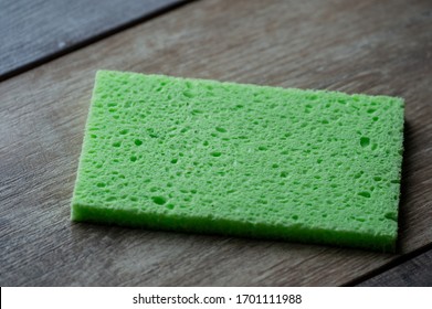 Cellulose sponge kitchen objects on the wood texture background. Cellulose napkin on the table.