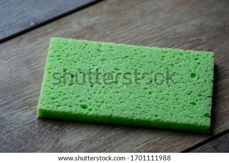 Cellulose sponge kitchen objects on the wood texture background. Cellulose napkin on the table.