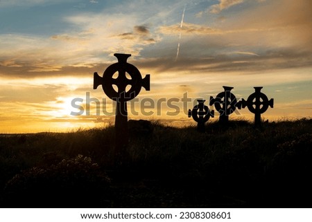 Celtic cross gravestone silhouettes at Cross Abbey graveyard, Mullet Peninsula, County Mayo, Ireland