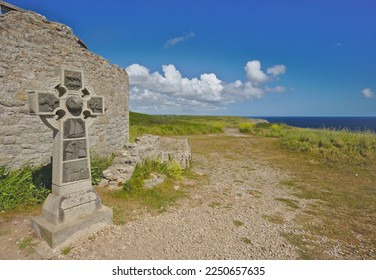 Celtic cross near the remains of an old medieval tower on Pointe du Raz. Brittany, France