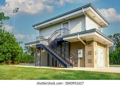 Cement Block And Vinyl Siding Building At Local Athletic Field With Black Metal Stairs