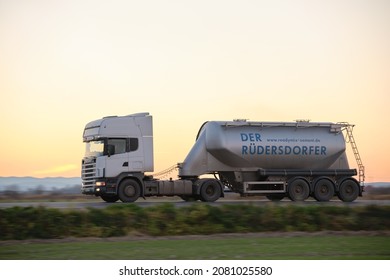 Cement cargo truck driving on highway hauling construction products. Delivery transportation and logistics concept. Kyiv, Ukraine - October 12, 2021.