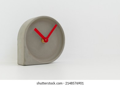 Cement Clock With Red Hands And No Numbers On Clock Face