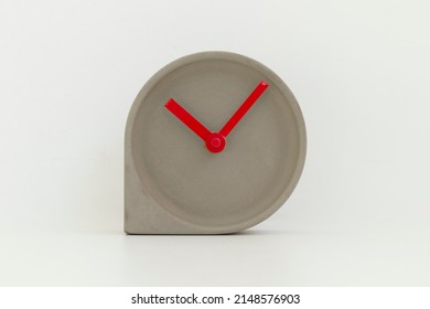 Cement Clock With Red Hands And No Numbers On Clock Face