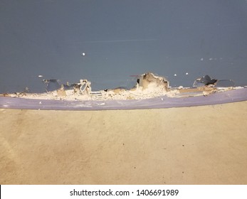 Cement Floor And Blue Wall With Broken Drywall