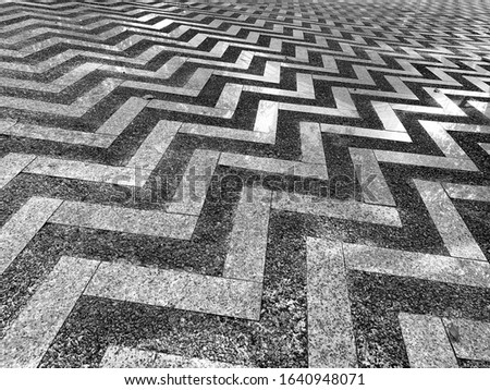 Cement floor decorated with marble with a zigzag pattern.