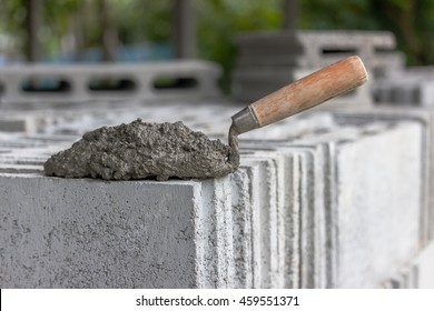 Cement mix or mortar with a trowel put on the brick for construction work.