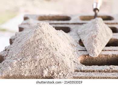 Cement or mortar, cement powder with a trowel and  cement powder pile put on the brick for construction work.