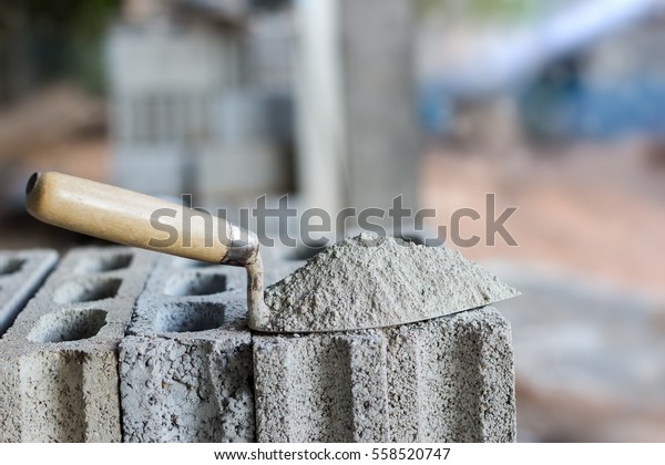 Cement or mortar, Cement powder with a\
trowel put on the brick for construction\
work.