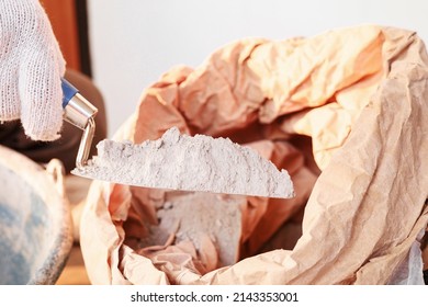 Cement or mortar, Cement powder with a trowel, worker scooping cement powder out of the bag for construction work.