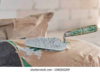 Cement or cement mortar with a trowel placed on a cement bag for construction work.