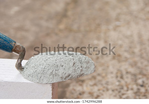 Cement powder or mortar with 
trowel put on the Lightweight Concrete brick for construction
work.
