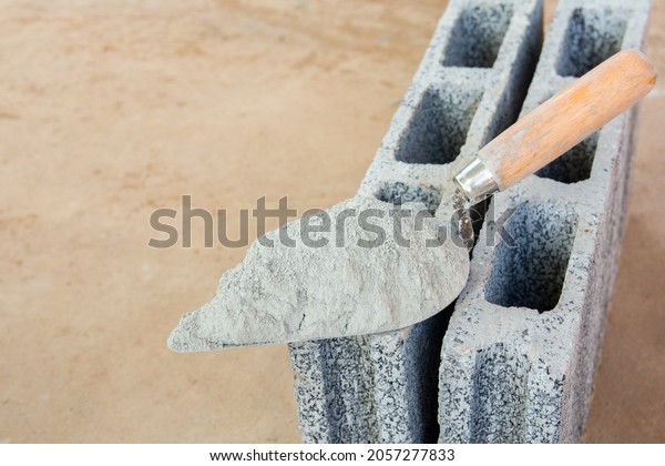 Cement powder or mortar with  trowel\
put on the Concrete brick for construction\
work.\

