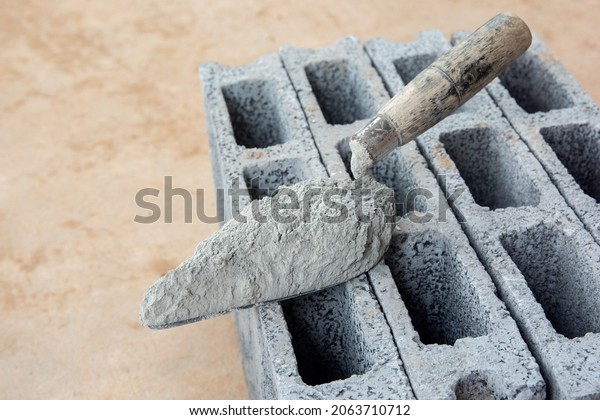 Cement powder or mortar with  trowel\
put on the Concrete brick for construction\
work.\
