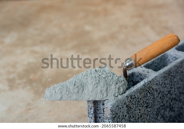 Cement powder or mortar with  trowel
put on the Concrete brick for construction
work.
