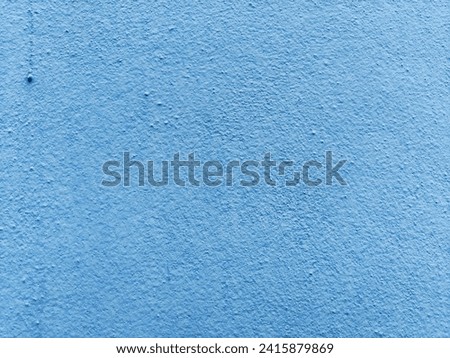 Cement wall with a light blue, rough surface. The highlight in the upper left corner looks like a water drop, looking charming.
