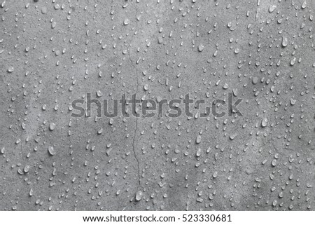 Cement wall texture background with water droplets and hairline cracks close up