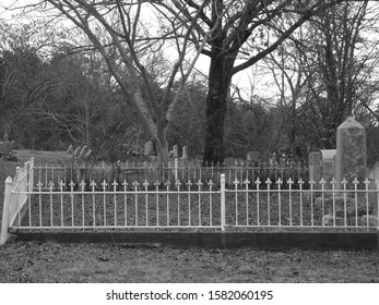 Cemetary Gate In Black And White With Headstones 