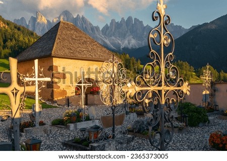 the cemetery of Church of St Magdalena which is full of crosses, situated under Odle Group Peaks.