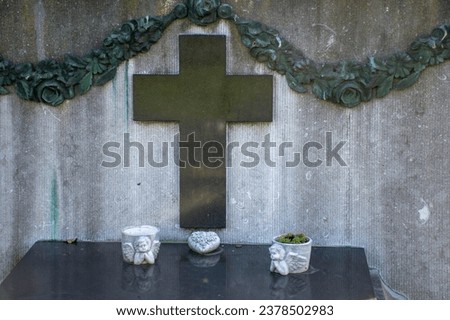 cemetery sculpture, a grave of the deceased with a cross and two little angels,All Saints' Day,